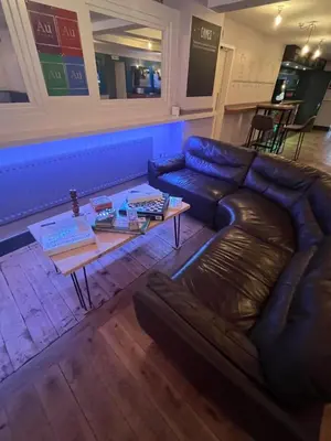 a living room with a leather couch and a coffee table at Hampton Hotel & restaurant in Llandrindod Wells