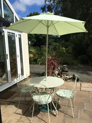 a table and chairs with an umbrella on a patio at Bron Hafren in Montgomery