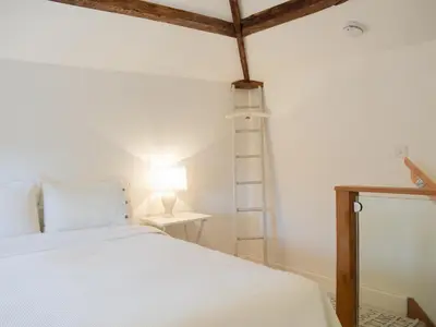a bedroom with a bed and a lamp and a ladder at Pepperpot Lodge in Baschurch