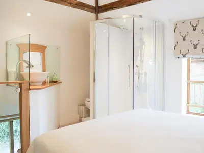 a bedroom with a shower and a white bed at Pepperpot Lodge in Baschurch