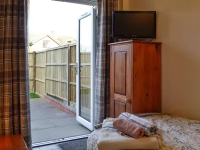 a bedroom with a tv and a sliding glass door at Penmaen in Talgarth
