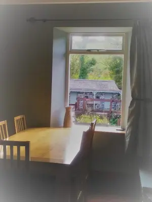 a dining room with a table and a window at Mill Cottage in Llanddeiniol