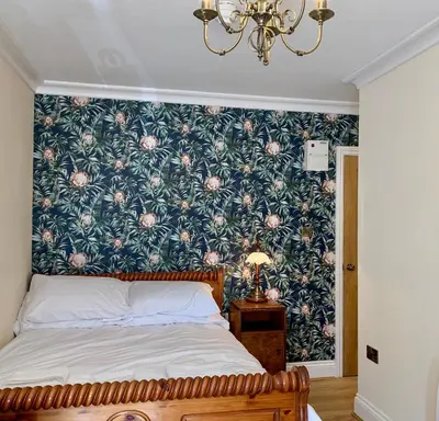 a bedroom with a bed with a floral wallpaper at The Royal in Barmouth