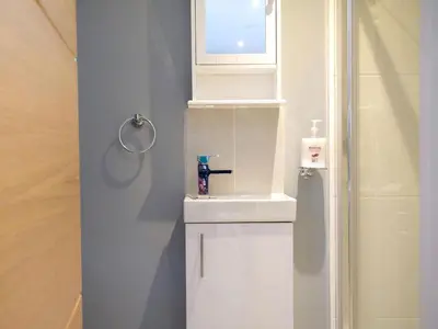 a white bathroom with a sink and a window at Windhover in Glasbury