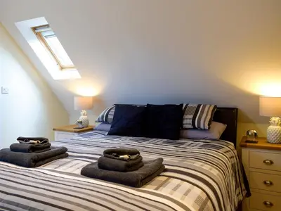 a bedroom with a bed with towels on it at Windhover in Glasbury