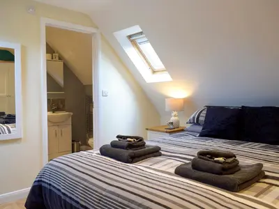 a bedroom with a bed with towels on it at Windhover in Glasbury