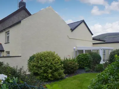 a white house with bushes in front of it at Pen Parc in Bryn-crug