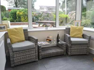 two chairs and a table in a room with windows at Pen Parc in Bryn-crug