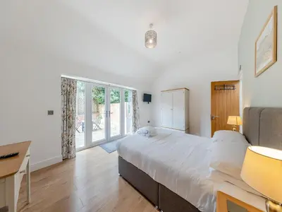 a bedroom with a large white bed and a desk at Y Stabl - Uk12742 in Acrefair