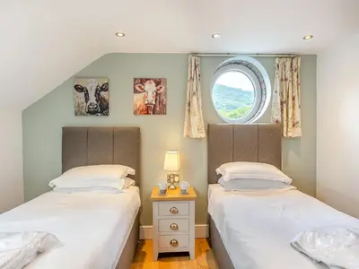 two twin beds in a room with a window at Ty Godro - Uk12745 in Acrefair