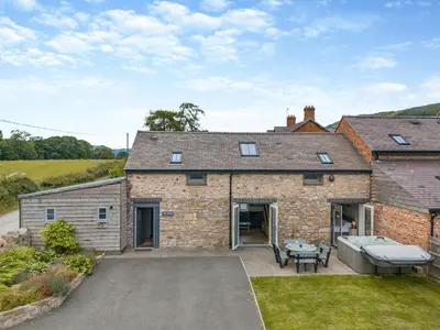 an external view of a brick house with a patio at Ty Godro - Uk12745 in Acrefair
