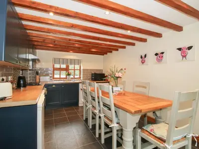 a kitchen with a wooden table and chairs at Old Hall Barn 3 in Church Stretton