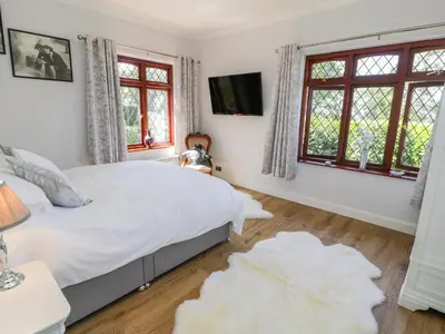 a bedroom with a bed and two windows at Berwyn in Talybont