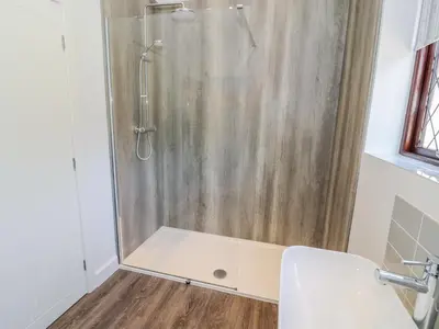 a shower stall in a bathroom with a toilet at Berwyn in Talybont
