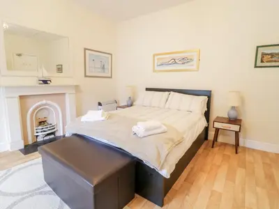 a bedroom with a large bed and a fireplace at Abermaw Views in Barmouth