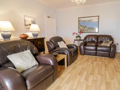 a living room with two leather chairs and a couch at Abermaw Views in Barmouth