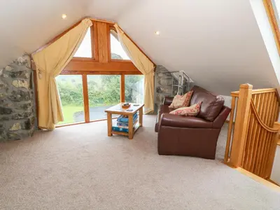 a living room with a couch and a window at Dysynni in Tywyn