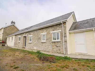 a brick house with white windows and a yard at Hen Brynbedw in Llanybydder