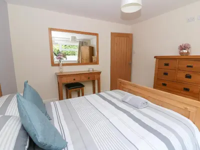 a bedroom with a bed and a dresser and a mirror at New Peny in Llandrindod Wells