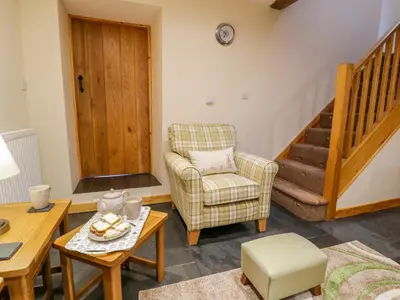 a living room with a chair and a table at Yr Hen Stabal in Blaenau-Ffestiniog
