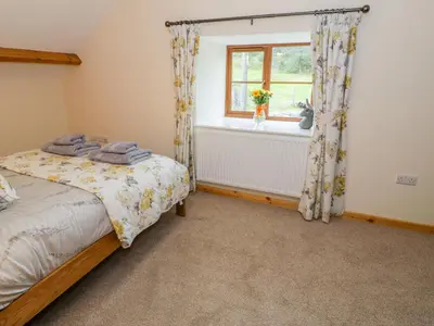 a bedroom with a bed and a window at Yr Hen Stabal in Blaenau-Ffestiniog