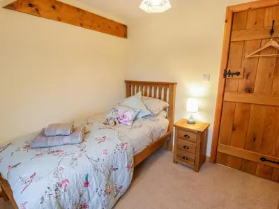 a bedroom with a bed and a wooden door at Yr Hen Stabal in Blaenau-Ffestiniog