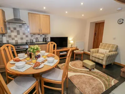 a kitchen and living room with a table and chairs at Yr Hen Stabal in Blaenau-Ffestiniog
