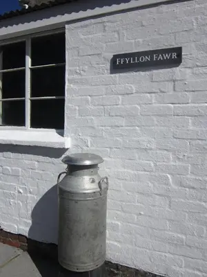 a white brick building with a vase in front of it at Ffyllon Fawr in Henfynyw Upper