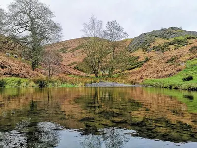 a body of water with mountains in the background at Romantic Cottage with Wood-fired Hot tub and Outdoor Pizza Oven in Shrewsbury
