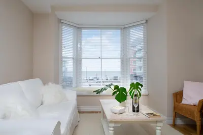 a living room with a white couch and a window at 1 Lisburne House in Aberystwyth