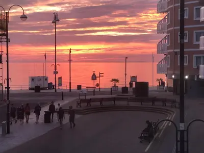 a group of people walking down a street at sunset at 1 Lisburne House in Aberystwyth