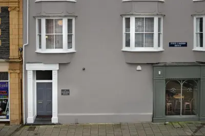 a white building with a blue door and windows at 1 Lisburne House in Aberystwyth