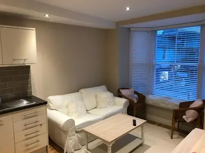 a living room with a white couch and a window at 1 Lisburne House in Aberystwyth