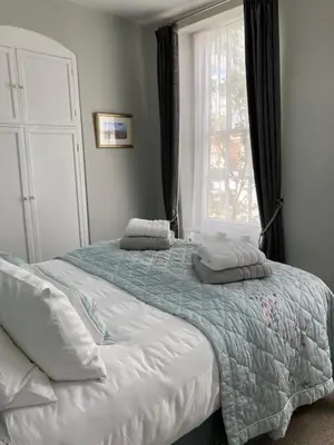 a bedroom with a large bed with a window at Assembly View - two bedroomed apartment with parking permit in Ludlow Town Centre in Ludlow