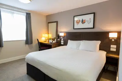 a hotel room with a large bed and a desk at Starling Cloud in Aberystwyth