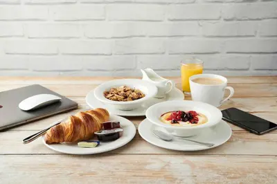 a table with two plates of breakfast food and a laptop at Starling Cloud in Aberystwyth
