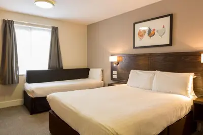 a hotel room with two beds and a couch at Starling Cloud in Aberystwyth