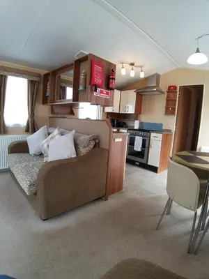 a living room with a couch and a kitchen at Clwyd 6 in Borth