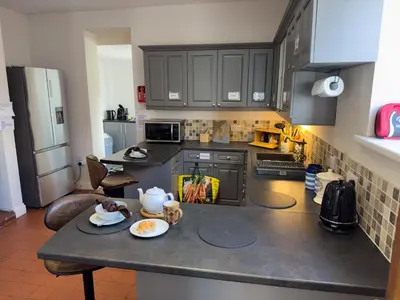 a kitchen with black cabinets and a counter top at Cliff haven in Borth