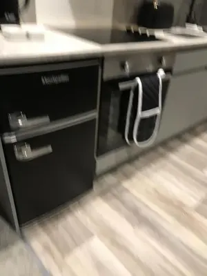 a kitchen counter with a black and white counter top at Sunset Studio Apartments in Aberaeron