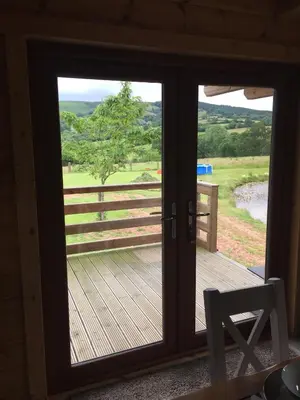 a sliding glass door with a view of a wooden deck at RedWood Lodge in Ludlow