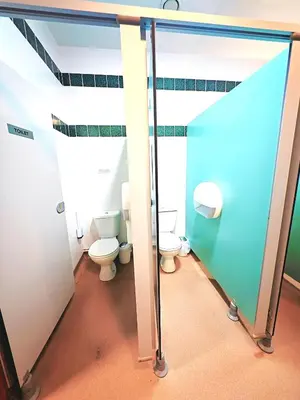 a bathroom with two toilets and a glass wall at Private Heated Bedrooms at The Bunkhouse in Snowdonia Perfect for Bikers and Walkers in Dolgellau