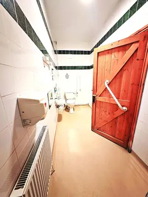 a bathroom with a toilet and a wooden door at Private Heated Bedrooms at The Bunkhouse in Snowdonia Perfect for Bikers and Walkers in Dolgellau