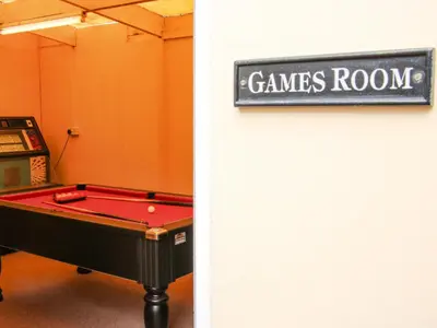 a room with a pool table and a sign that reads games room at Sunningdale in Ludlow