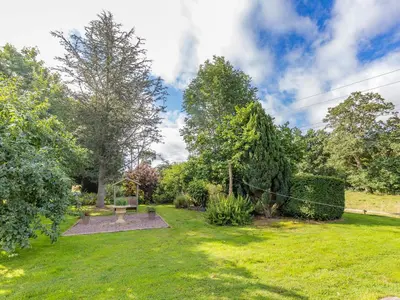 a garden with a bench in the grass at Riverside in Craven Arms