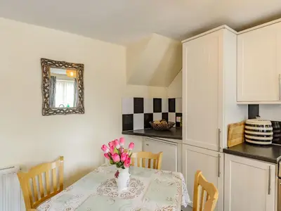 a kitchen with a table with a vase of flowers on it at Yew Tree Cottage in Welshpool
