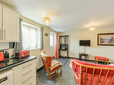 a kitchen with a counter and chairs in a room at Yew Tree Cottage in Welshpool