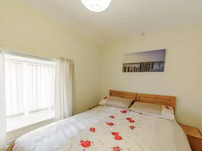 a bedroom with a bed with red flowers on it at Yew Tree Cottage in Welshpool