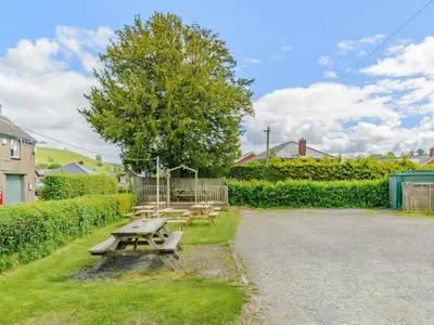 a picnic table and benches in a yard at Yew Tree Cottage in Welshpool