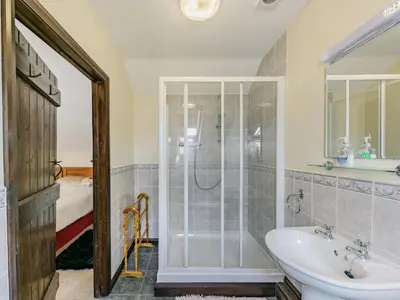 a bathroom with a shower and a sink at Yew Tree Cottage in Welshpool